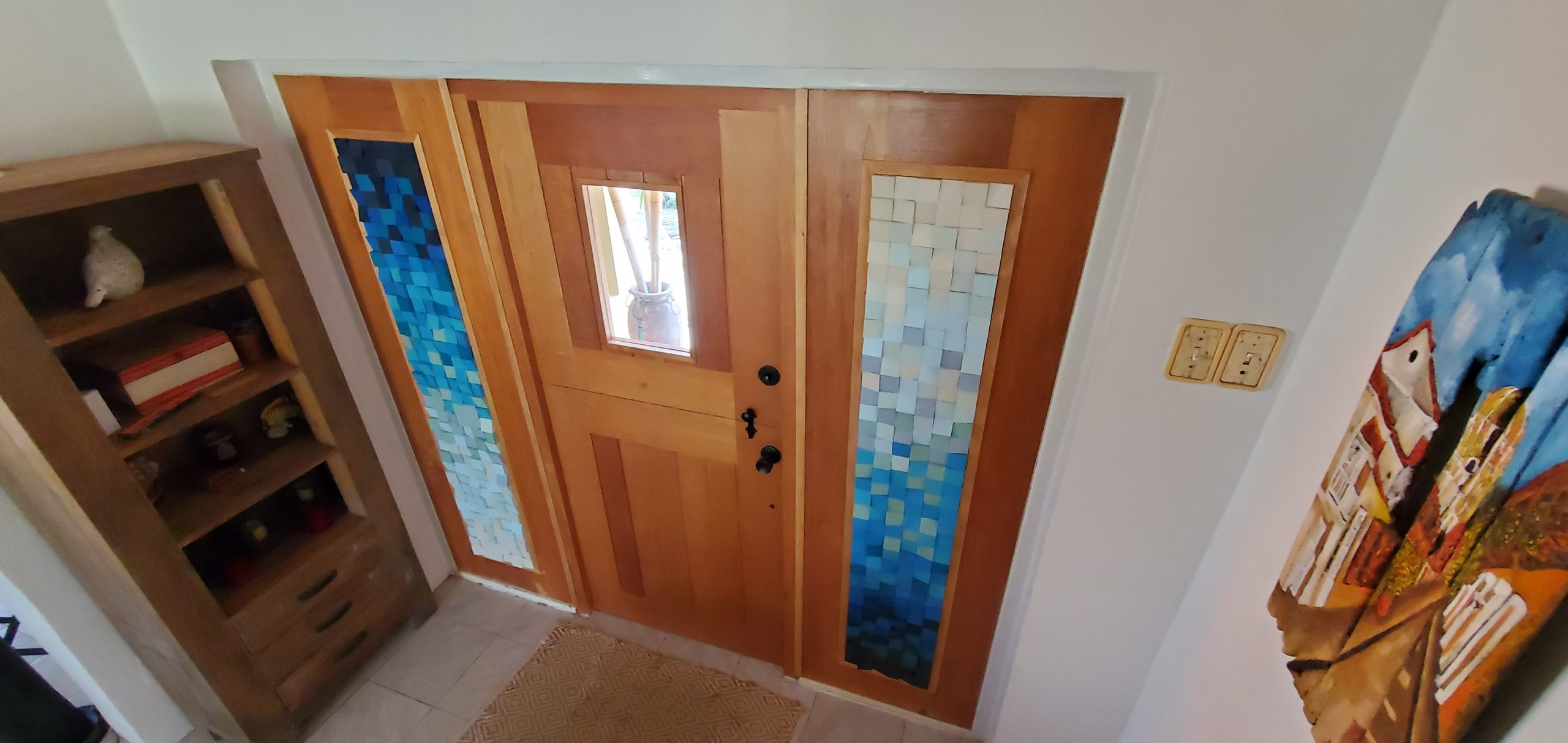 Two vertical blue and white modular panels on either side of an entrance door.