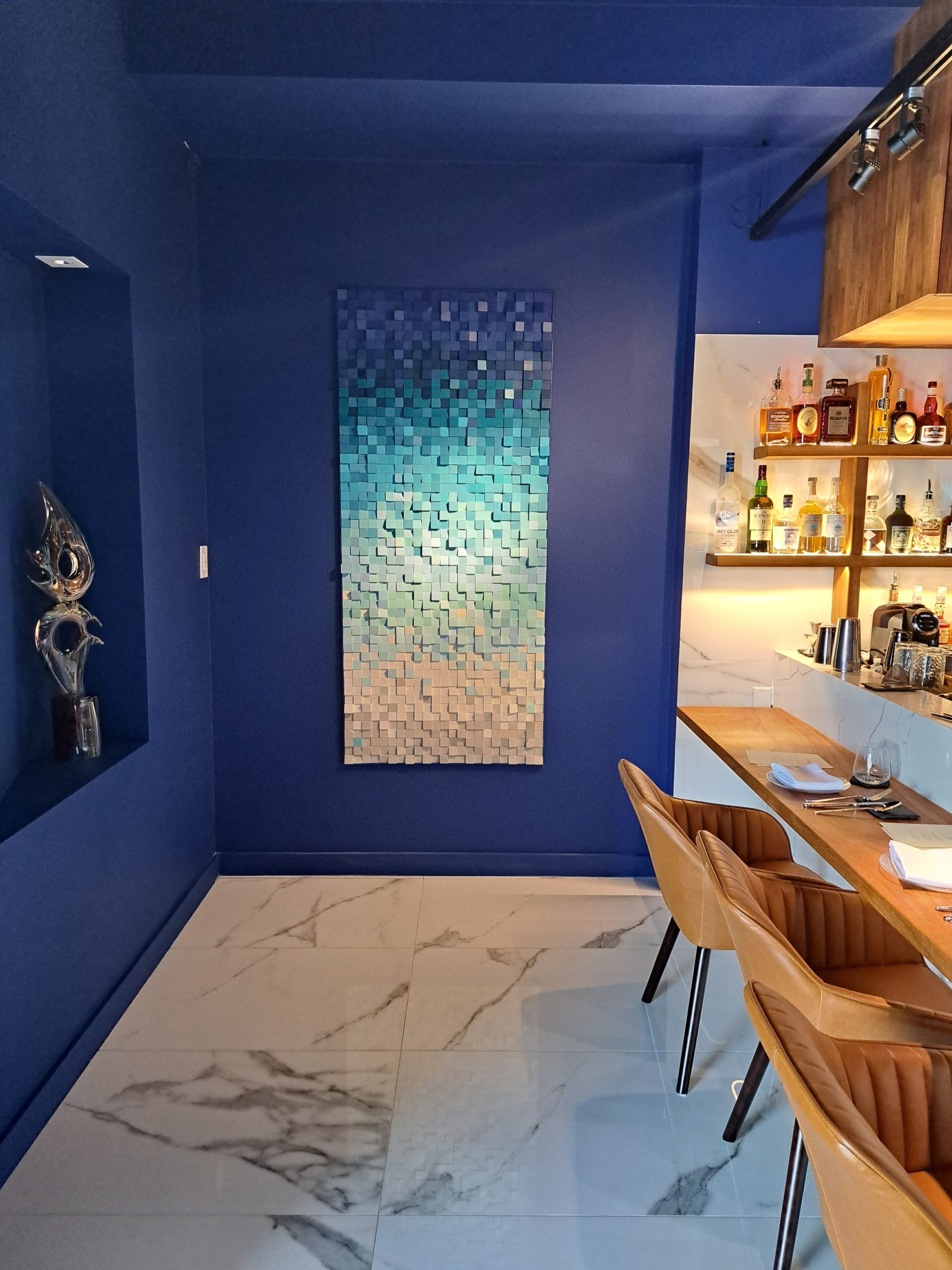 Vertical relief with blue, turquoise and sand-colored modules at Ever Restaurante.