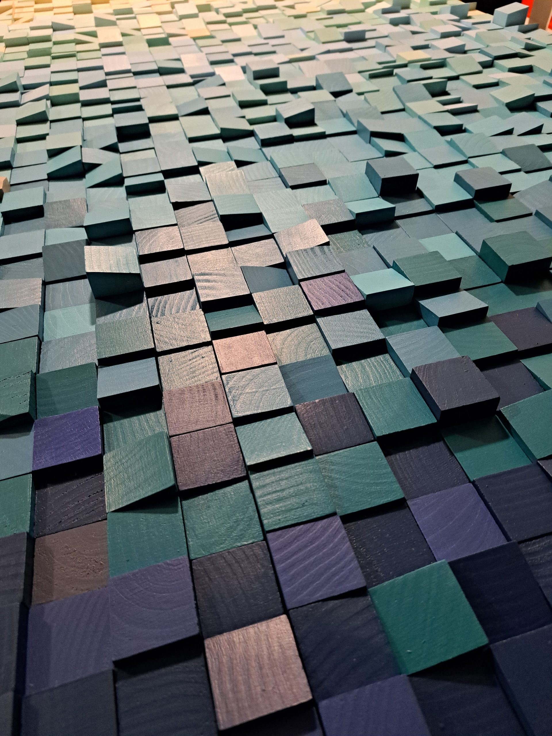 Close-up of painted wooden modules showing their grain and depth.